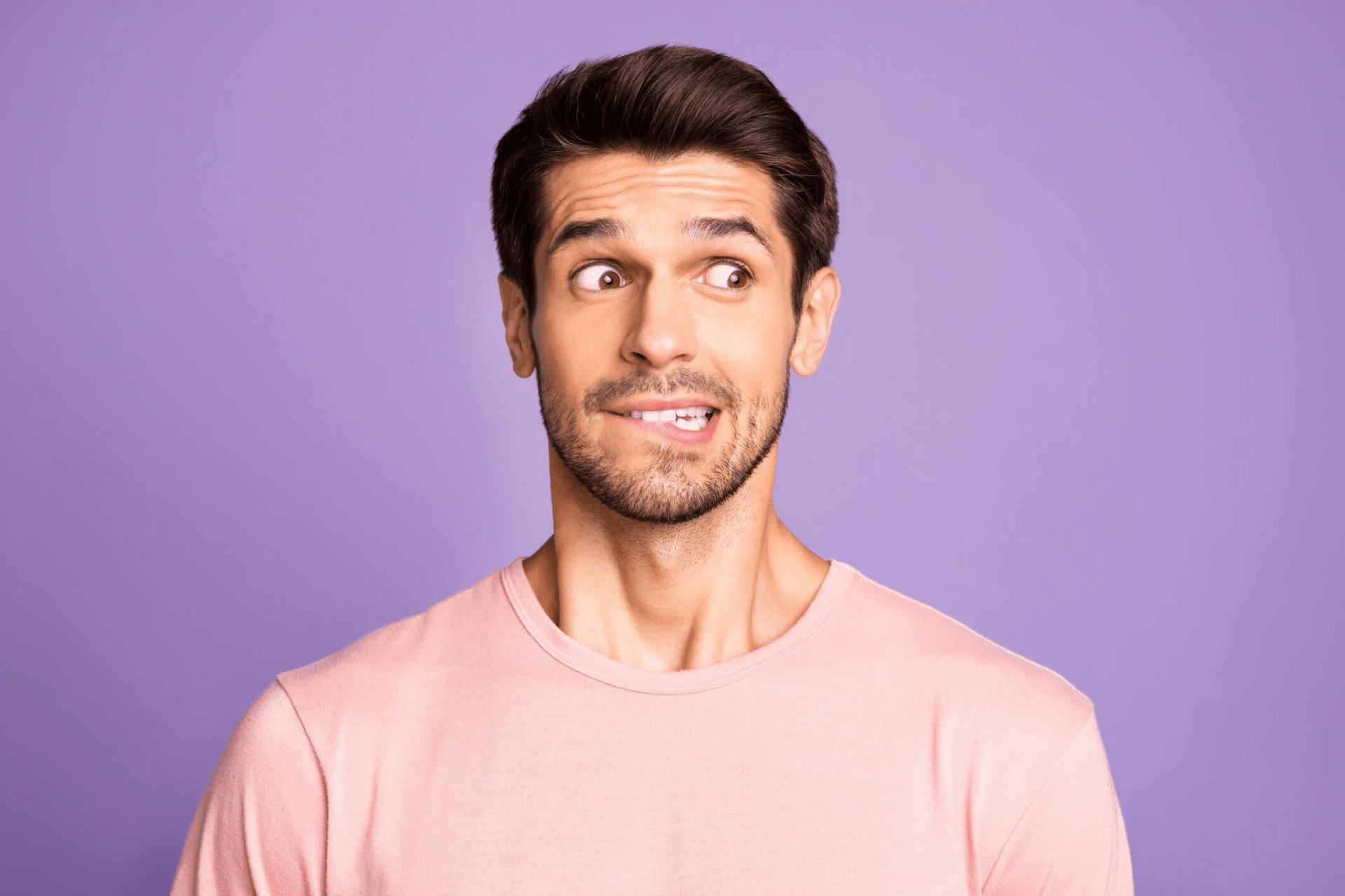 Man smiling and looking to the side against a purple background